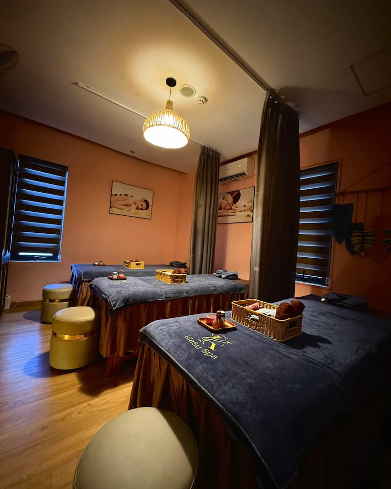 A serene and private massage room at Kiasu Spa with three neatly prepared treatment beds.