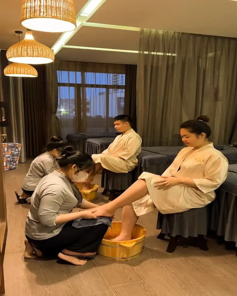 Guests enjoying a relaxing herbal foot bath and massage in a luxurious room at Kiasu Spa.