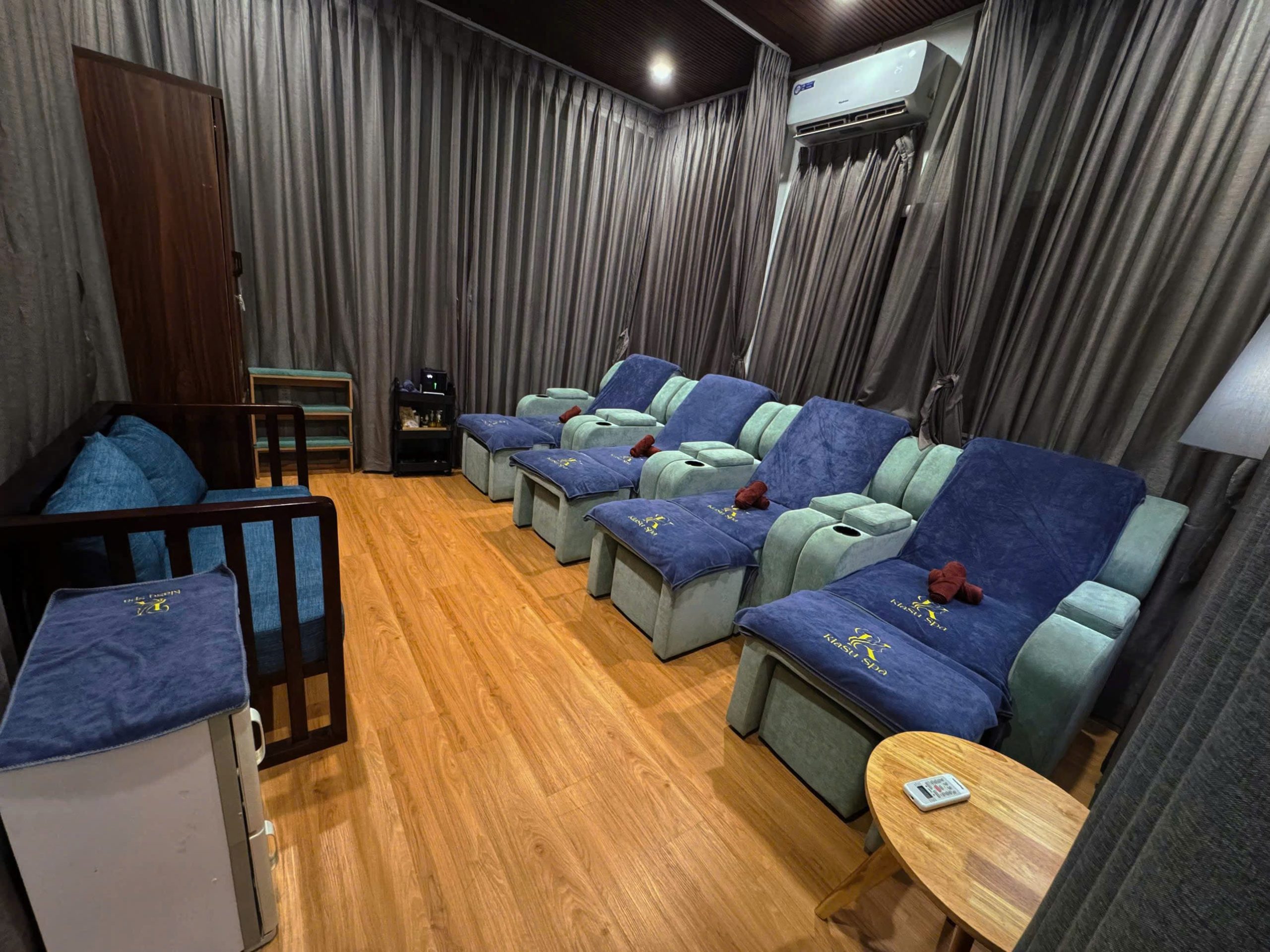 Private foot massage lounge at Kiasu Spa with comfortable recliner chairs and serene ambiance.